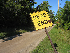 dead-end yellow dead-end sign on a dirt road